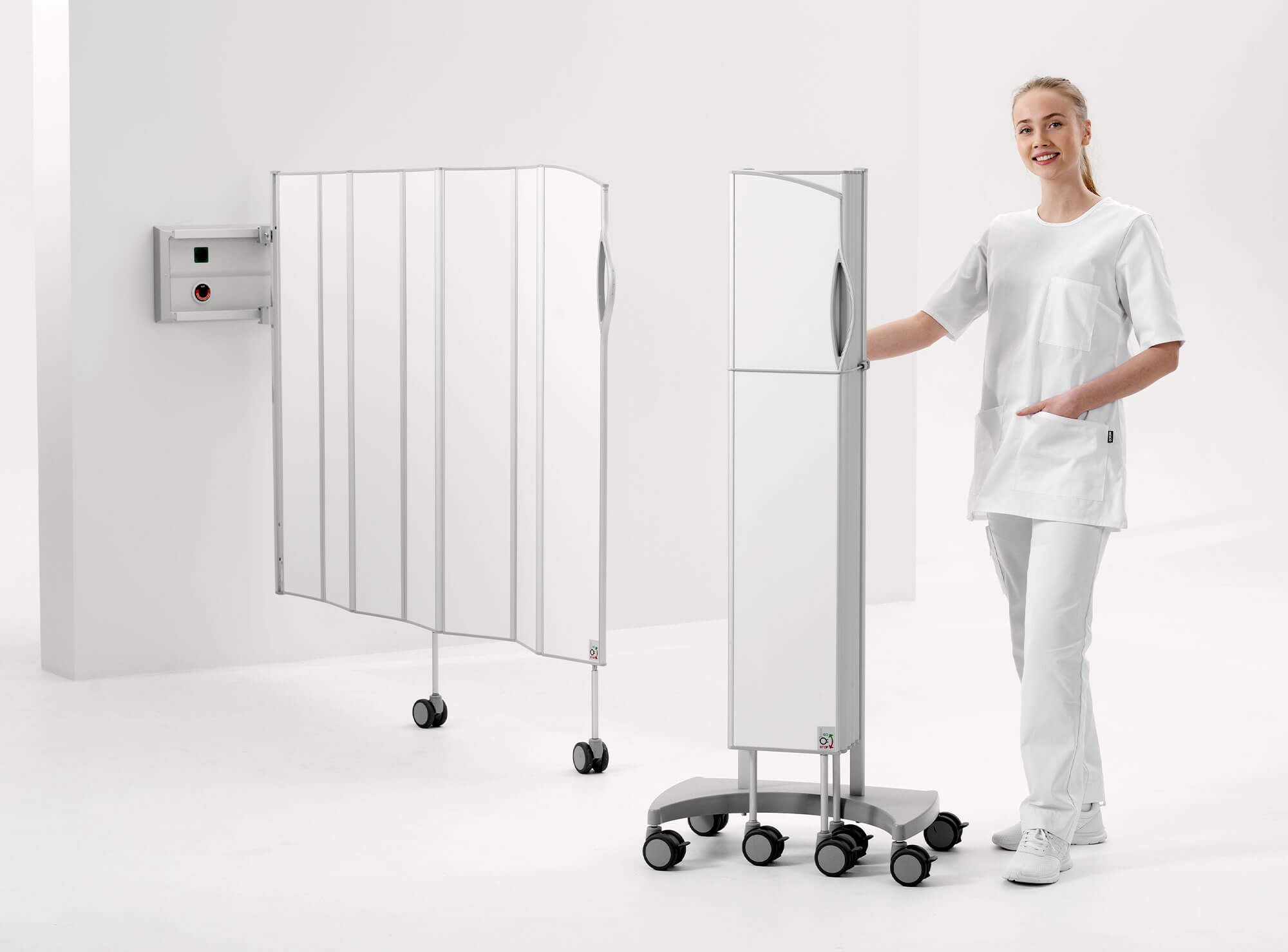 Infirmière présentant un paravent Silentia Fold mural et un paravent mobile sur base à roulettes.