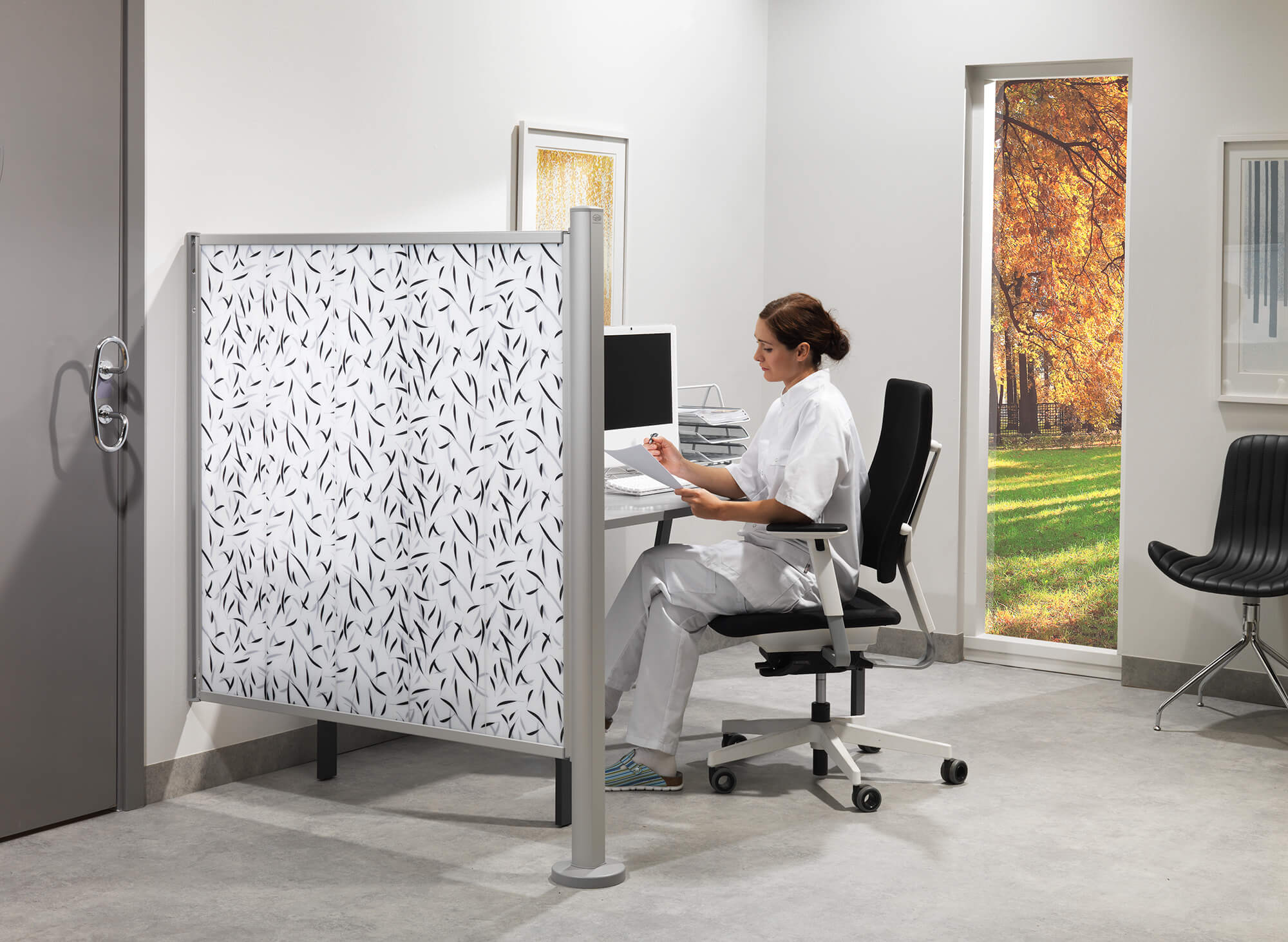 Silentia Fixed con PhotoPanels estampados que protege un puesto de escritorio en una clínica.