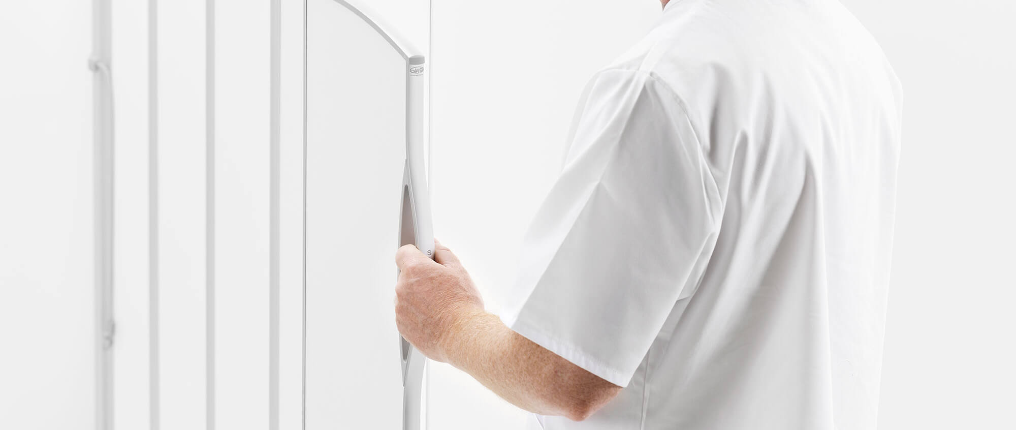 Nurse in white uniform gripping the handle of a white Silentia folding screen, inviting newsletter sign-up.