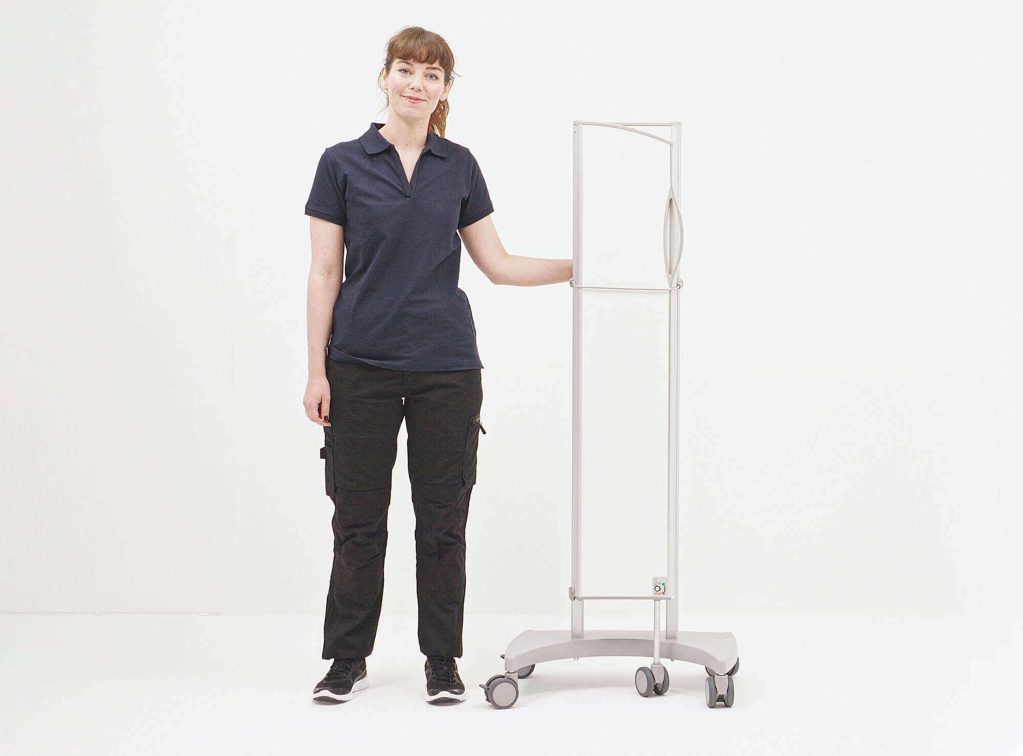 Technicus naast een ingeklapt Silentia Fold-scherm op een verrijdbare voet voor mobiele configuratie.
