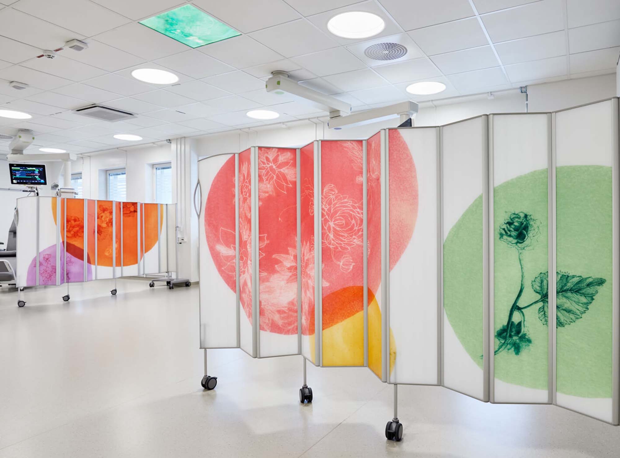 Flur, abgeschirmt durch Silentia Fold PhotoPanels™, bedruckt mit roten und grünen floralen Kreisen.