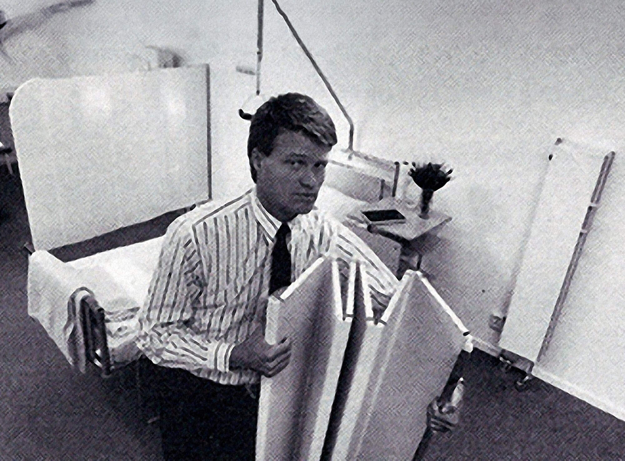 Vintage black-and-white photo of Silentia's founder carrying an early folding hospital screen, the original design.