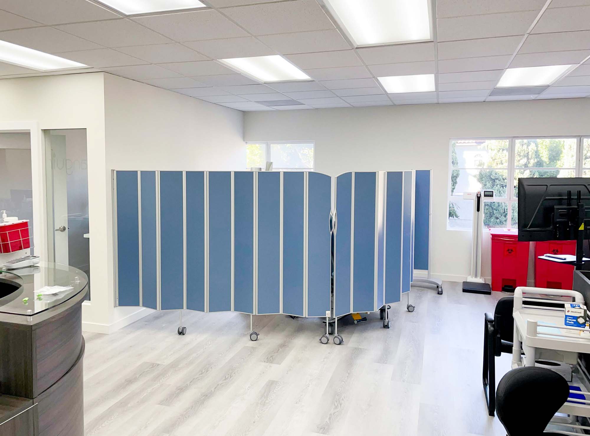 Blue Silentia Fold screen dividing an open laboratory or clinic space beside a reception counter.