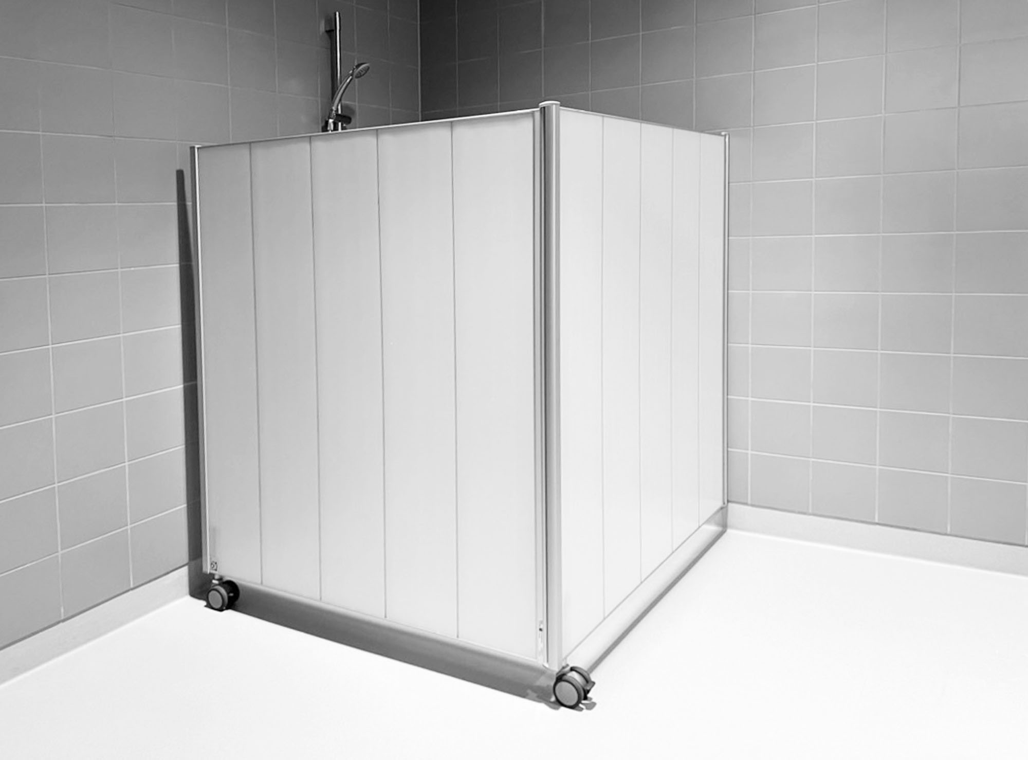 Mampara Silentia Shower plegada en una esquina alrededor de una ducha en un cuarto húmedo alicatado.