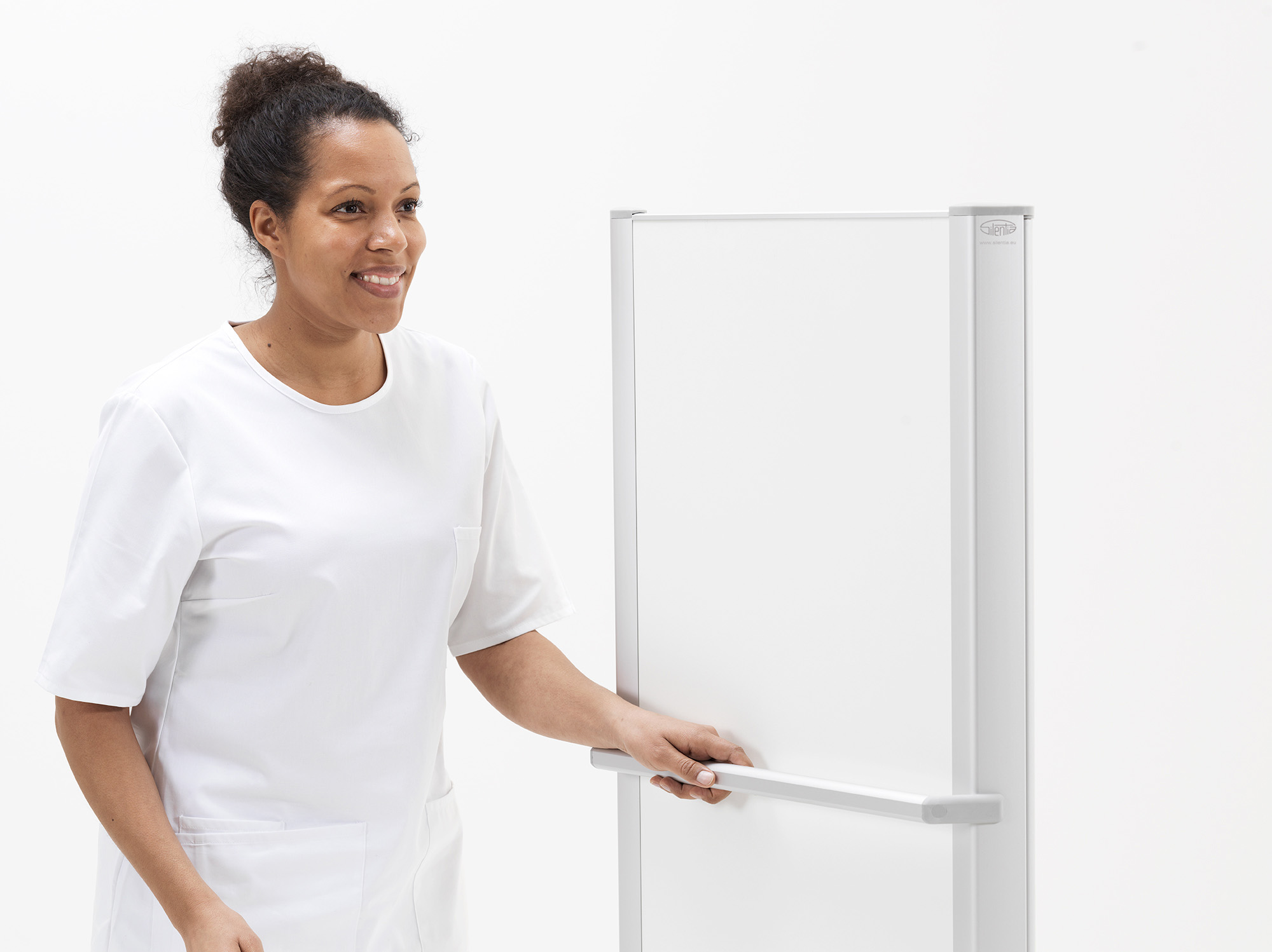 Healthcare professional moving a Silentia Wing mobile bed end screen by its handle